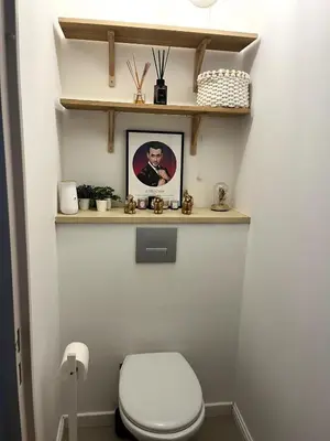 a bathroom with a white toilet and shelves at Appartement calme vue mer in Saint-Laurent-du-Var