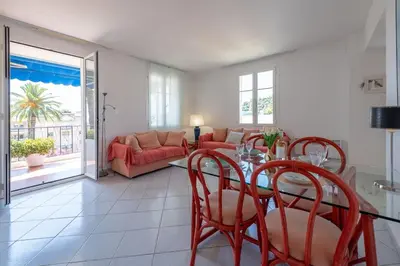 a living room with a table and chairs and a couch at Beaulieu Garden Apartment in Beaulieu-sur-Mer