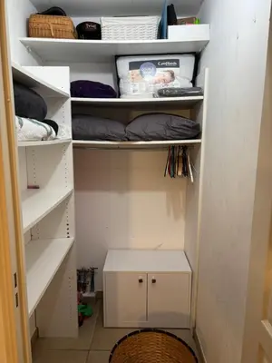 a walk in closet with white shelves and a box at Magnifique studio avec terrasse et jardin in Nice