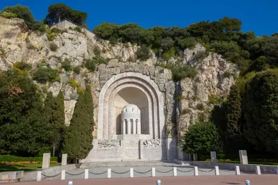 a building in front of a rocky mountain at Capitol Close To The Beach - Happy Rentals in Nice