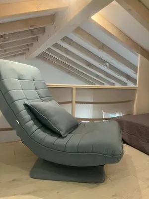 a grey chair with a pillow in a bedroom at Cosy studio piscine eze bord de mer in Èze