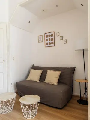 a living room with a couch and two tables at Studio cosy dans une belle copropriete classee in Nice