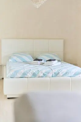 a white bed with blue sheets in a bedroom at Appartement 3 pièces Nice-Ouest in Nice