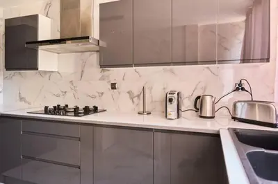 a kitchen with white marble counter tops and a sink at Appartement 3 pièces Nice-Ouest in Nice