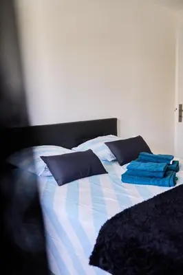 a bed with blue and white sheets and pillows at Appartement Moderne 4 pièces Nice-Ouest in Nice