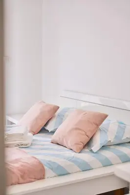 a bed with pink pillows on top of it at Appartement Moderne 4 pièces Nice-Ouest in Nice