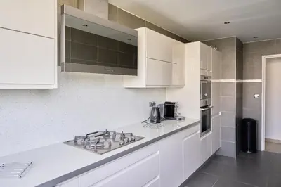 a kitchen with white cabinets and a counter top at Appartement Moderne 4 pièces Nice-Ouest in Nice