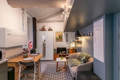 a kitchen and living room with a table and a couch at Cute duplex studio in Nice