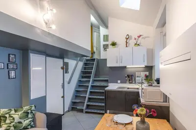 a kitchen with a staircase and a living room at Cute duplex studio in Nice