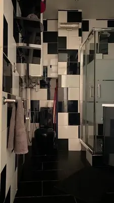 a bathroom with a black and white tile wall at République in Nice