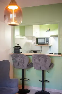 a kitchen with two chairs and a counter with a microwave at Studio Nice , proche mer et aéroport in Nice