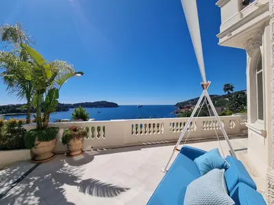 a swing on a balcony with a view of the ocean at Villa Soleil Riviera in Villefranche-sur-Mer