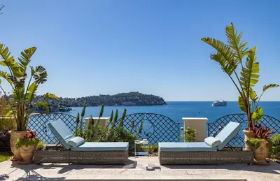 two lounge chairs and a view of the ocean at Villa Soleil Riviera in Villefranche-sur-Mer