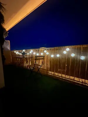 a table and chairs on a fence at night at Appartement-Centre ville -Climatisé-Terrasse-Parking in Cagnes-sur-Mer