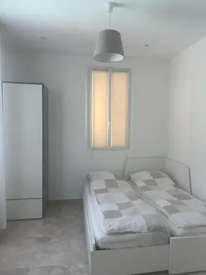 a white room with a bed and a window at Katy in Nice