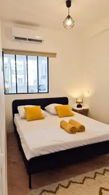 a bedroom with a large bed with yellow pillows at Superbe appartement 3P neuf - terrasse - barbecue in Nice