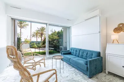 a living room with a blue couch and chairs at Sea View & Terrace Promenade des Anglais in Nice