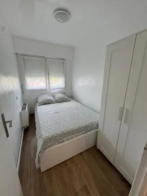 a small white bedroom with a bed and a window at Apartment in Cros de Cagnes in Cagnes-sur-Mer
