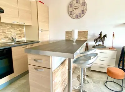 a kitchen with a counter and a clock on the wall at Apartment in Cros de Cagnes in Cagnes-sur-Mer