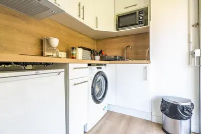 a kitchen with a washing machine and a microwave at L'Échappée Belle in Nice