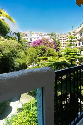 a balcony with a view of a garden and buildings at L'Échappée Belle in Nice