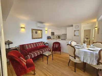 a living room with a red couch and a table at Villa Ninette avec rooftop in Villefranche-sur-Mer