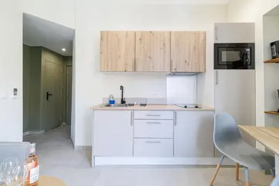 a kitchen with white cabinets and a table at T2 situé au centre-ville de Nice in Nice