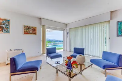 a living room with blue chairs and a glass table at VILLA DYONIS VI4439 by Riviera Holiday Homes in Nice