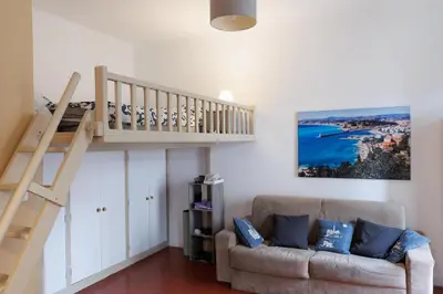 a bed in a room with a painting on the wall at charmant studio sur le port de Nice in Nice