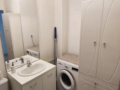 a white bathroom with a sink and a washing machine at Appartement deux pièces bien situé et pratique in Nice