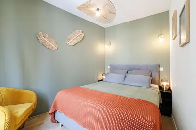 a small bedroom with a bed with an orange blanket at Appartement confort centre ville de Nice in Nice