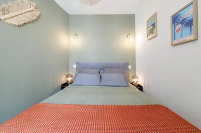 a bedroom with a bed with an orange bedspread at Appartement confort centre ville de Nice in Nice