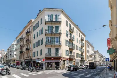 a tall building on a city street with cars parked at Appartement confort centre ville de Nice in Nice