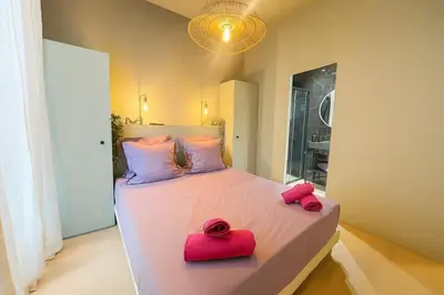 a bedroom with a large bed with two red pillows at Central- walk to Massena & Beach in Nice
