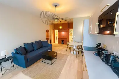 a living room with a blue couch and a table at Central- walk to Massena & Beach in Nice