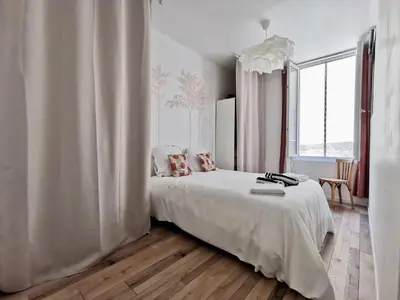 a white bedroom with a bed and a window at Cosy Savoie by Bookking Guys in Nice