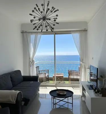 a living room with a couch and a large window at 2 Pièce - Promenade des Anglais in Nice