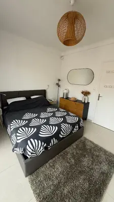a bedroom with a black and white bed and a rug at 2 Pièce - Promenade des Anglais in Nice