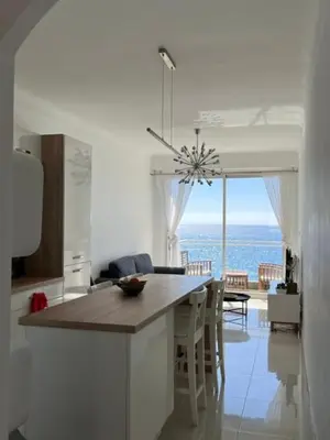 a kitchen with a table and a view of the ocean at 2 Pièce - Promenade des Anglais in Nice