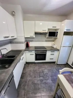 a kitchen with white cabinets and a sink at Ferber Garden - Appartement de charme avec deck privé in Nice