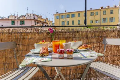 a table with food and drinks on a balcony at MY CASA - CASSINI - Garibaldi Square - AC in Nice