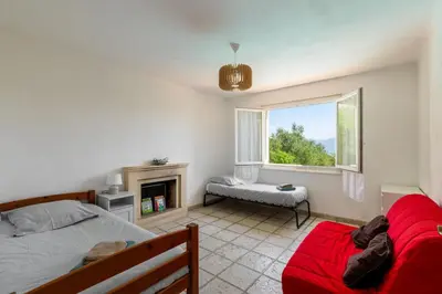 a bedroom with a bed and a fireplace and a window at Villa les Oliviers in La Gaude