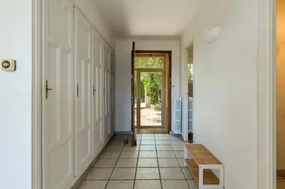 a hallway with a door and a tiled floor at Villa les Oliviers in La Gaude