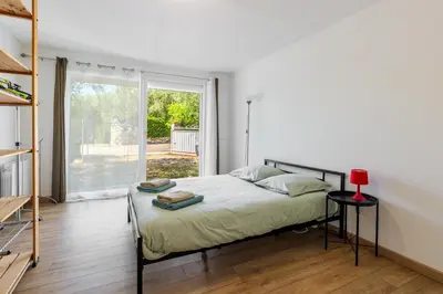 a bedroom with a bed and a large window at Villa les Oliviers in La Gaude