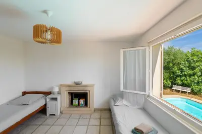 a bedroom with a bed and a fireplace and a window at Villa les Oliviers in La Gaude