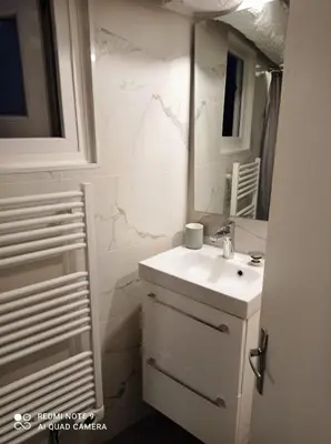 a white bathroom with a sink and a mirror at Studio dernier étage vieux Nice centre in Nice