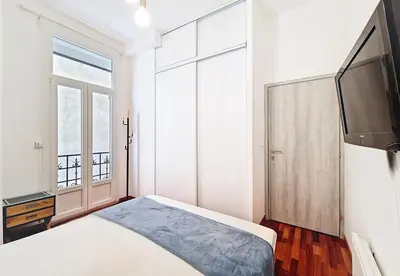 a bedroom with a bed and a flat screen tv at Nestor&Jeeves - OASIS - Terrace in the city in Nice