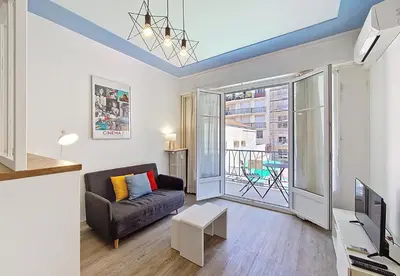 a living room with a couch and a large window at Nestor&Jeeves - ESPRIT SUD - Near Promenade des Anglais in Nice