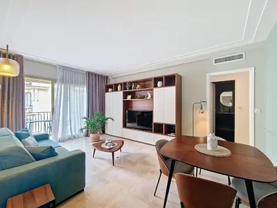 a living room with a blue couch and a table at Nestor&Jeeves - VICTORIA - Delux apartment city center in Nice