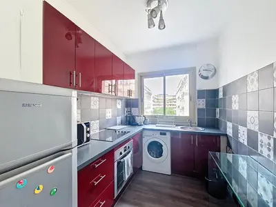 a kitchen with red cabinets and a washing machine at Nestor&Jeeves - VICTORIA - Delux apartment city center in Nice